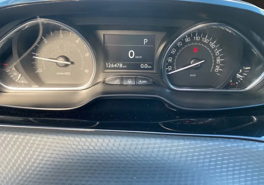 Vue rapprochée du tableau de bord du Peugeot 2008 gris platinium, affichant le compteur et l’odomètre à 126478 km.