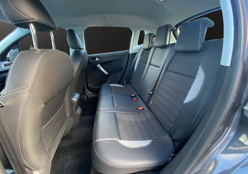 Vue intérieure côté arrière droit du Peugeot 2008 gris platinium, montrant les sièges arrière en tissu et cuir noir.