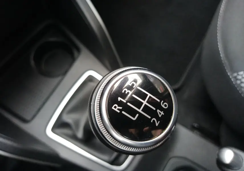 Gros plan sur le levier de vitesses manuel du Dacia Duster 2021, intérieur noir avec coutures grises visibles.