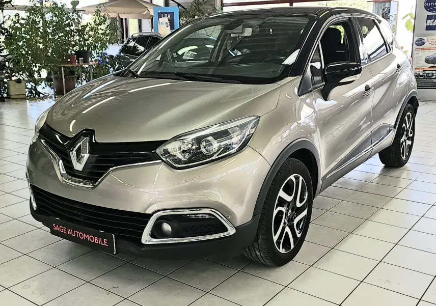 Vue 3/4 avant d’un Renault Captur gris métallisé de 2014 avec jantes alliage et calandre noire brillante.