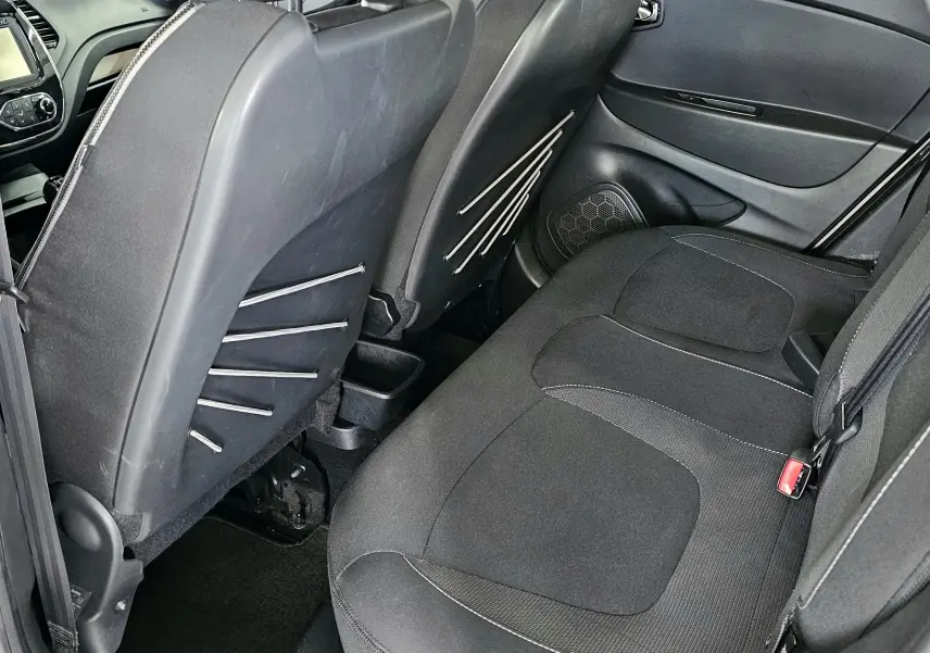 Vue intérieure arrière côté droit du Renault Captur gris 2014, montrant les sièges arrière et le dos des sièges avant.