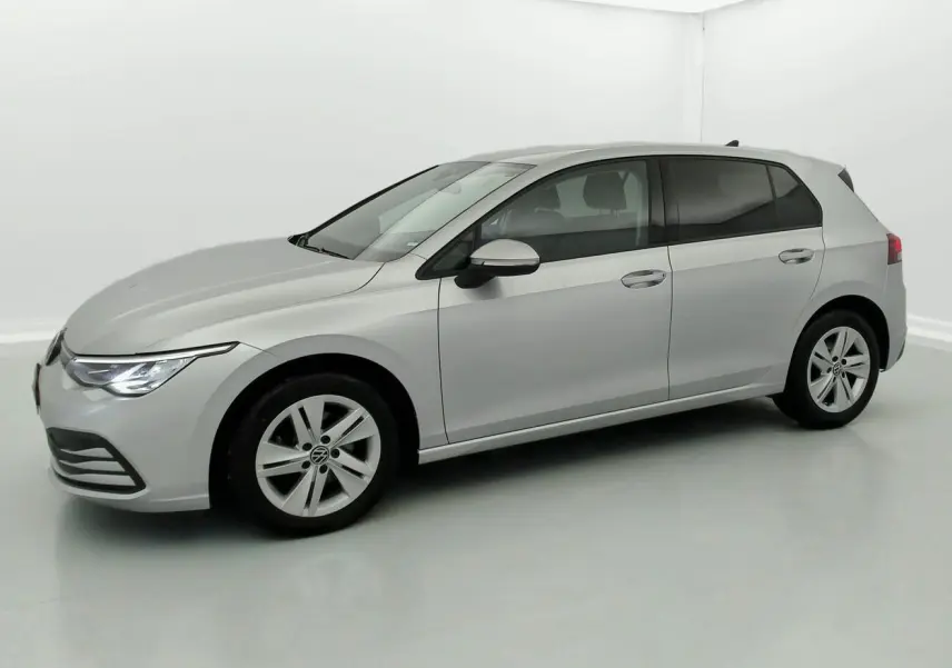 Volkswagen Golf VIII gris reflex vue de profil côté gauche dans un studio lumineux, avec phares allumés.