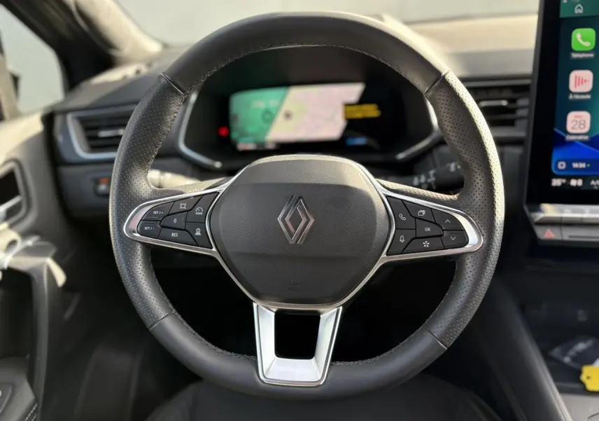 Volant en cuir noir avec commandes intégrées et logo Renault, vue frontale de l'habitacle du Symbioz E-Tech 2025.