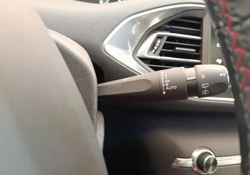 Gros plan sur la commande d’essuie-glace côté gauche du tableau de bord noir de la Peugeot 308 GT Line.