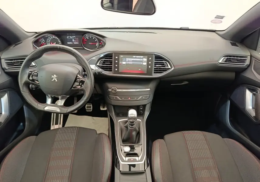 Vue intérieure avant de la Peugeot 308 GT Line 2016, volant cuir multifonctions et écran tactile central noir.