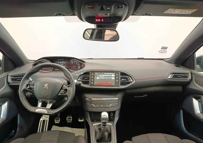 Vue intérieure avant de la Peugeot 308 GT Line 2016, tableau de bord noir avec volant cuir multifonctions et écran tactile central.
