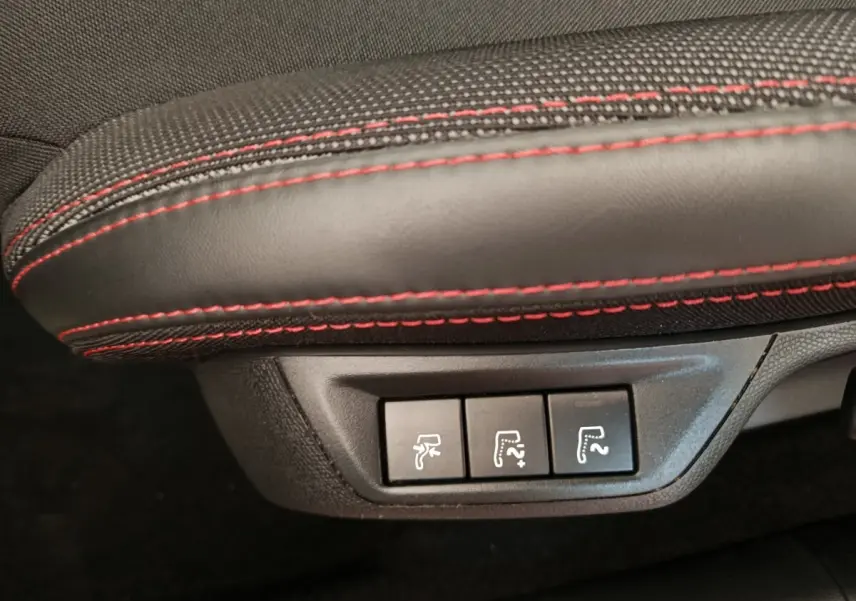 Gros plan sur les commandes de réglage des sièges en cuir noir avec surpiqûres rouges d'une Peugeot 308 GT Line 2016.