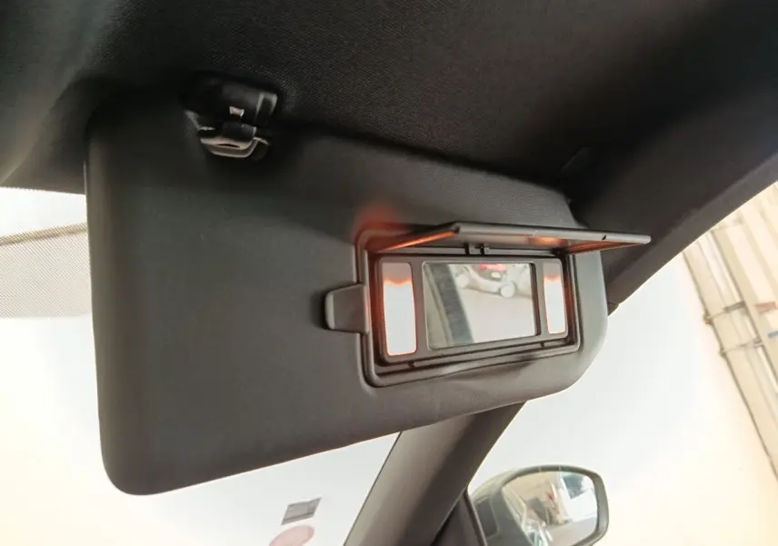 Détail du pare-soleil intérieur avec miroir éclairé, côté conducteur, dans une Peugeot 308 noire de 2016.