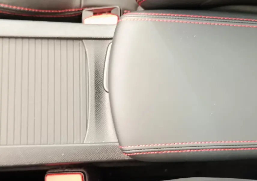 Gros plan sur l'accoudoir central noir avec surpiqûres rouges dans l'habitacle d'une Peugeot 308 GT Line 2016.