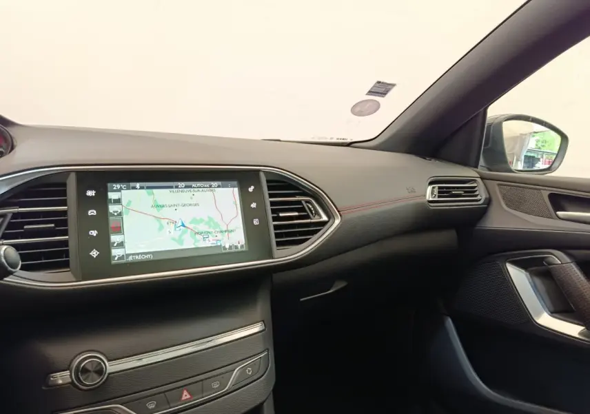 Vue intérieure côté passager du tableau de bord noir de la Peugeot 308 GT Line avec écran tactile de navigation 9,7 pouces.
