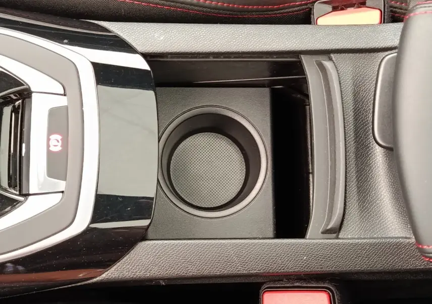 Vue plongeante sur la console centrale noire de la Peugeot 308 GT Line 2016 avec porte-gobelet et surpiqûres rouges.
