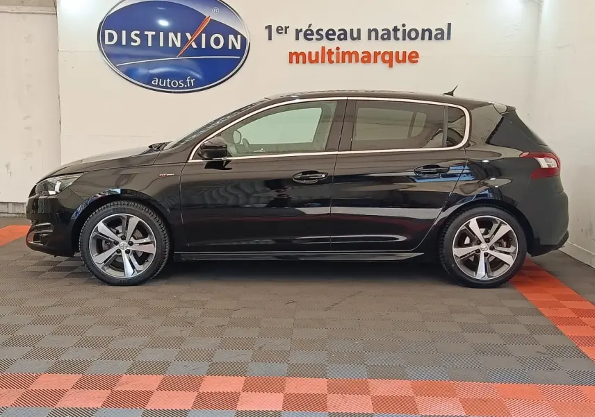 Vue latérale droite d'une Peugeot 308 noire GT Line de 2016, avec jantes alliage et logo GT sur l'aile avant.
