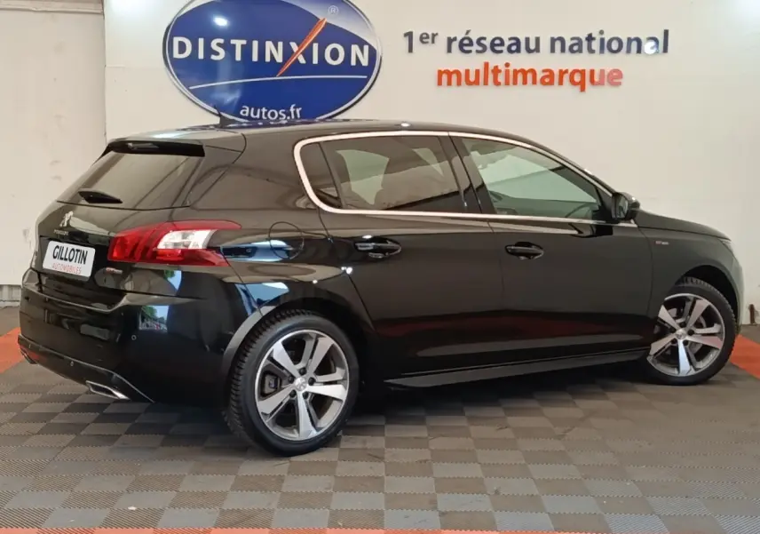 Peugeot 308 noir vue de profil droit en intérieur, avec jantes alliage et feux arrière distinctifs.