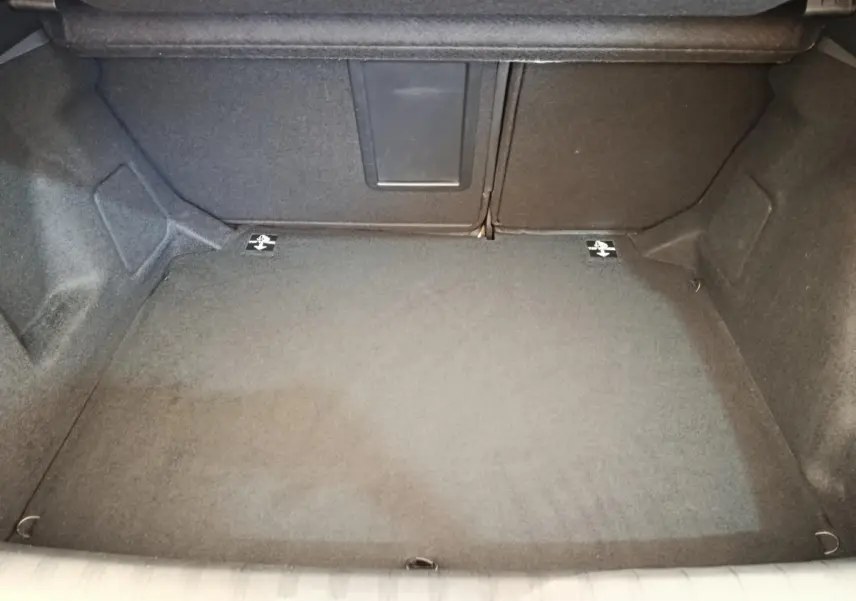 Coffre ouvert de la Peugeot 308 noir, vue intérieure montrant la banquette rabattable avec trappe à ski.