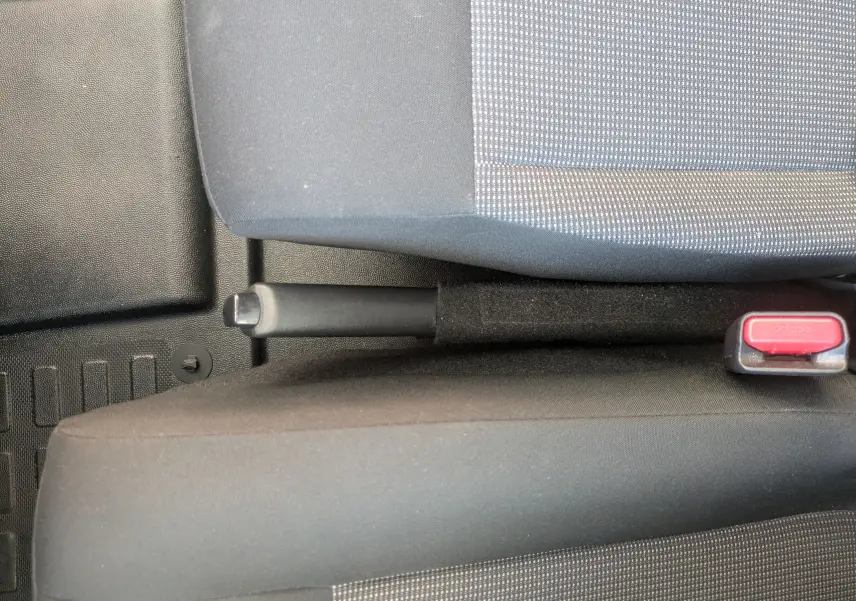 Vue rapprochée de la poignée de frein à main et de la ceinture de sécurité entre les sièges avant du Fiat Scudo Fourgon blanc.