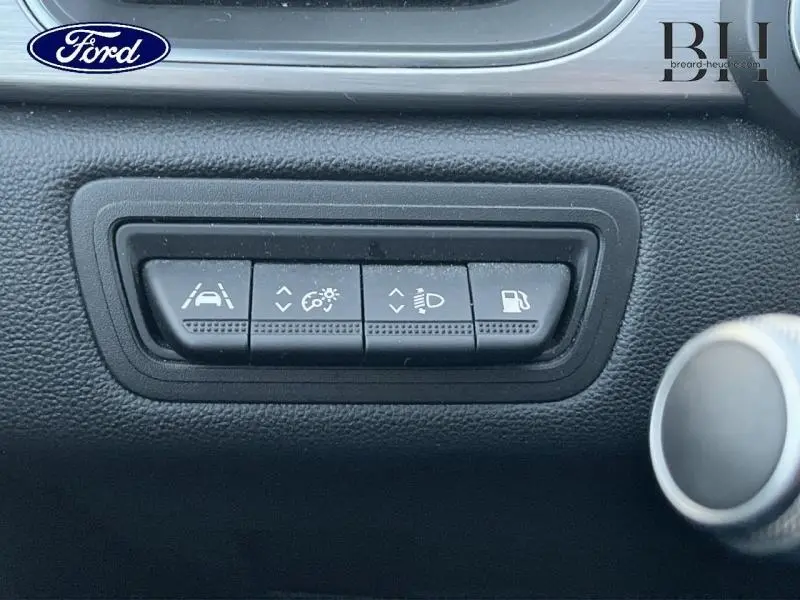 Panneau de commandes noires avec quatre boutons de réglage d'assistance et éclairage, intérieur d'un Renault Captur gris Highland/Noir Etoile.
