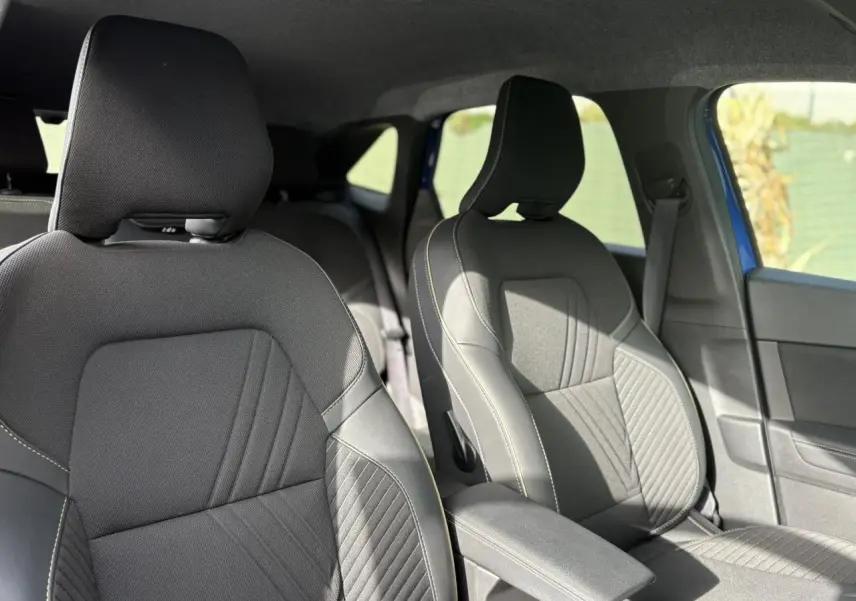 Vue intérieure des sièges avant gris foncé avec surpiqûres claires de la Renault SYMBIOZ E-Tech Full Hybrid 2025.