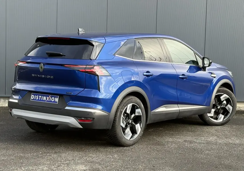 Renault Symbioz E-Tech hybride bleu Iron en 3/4 arrière droit, avec jantes 18 pouces et hayon mains libres.