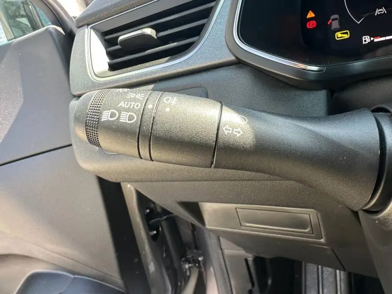 Gros plan sur la commande des phares et clignotants dans l'habitacle du Renault Captur gris métallisé 2025.