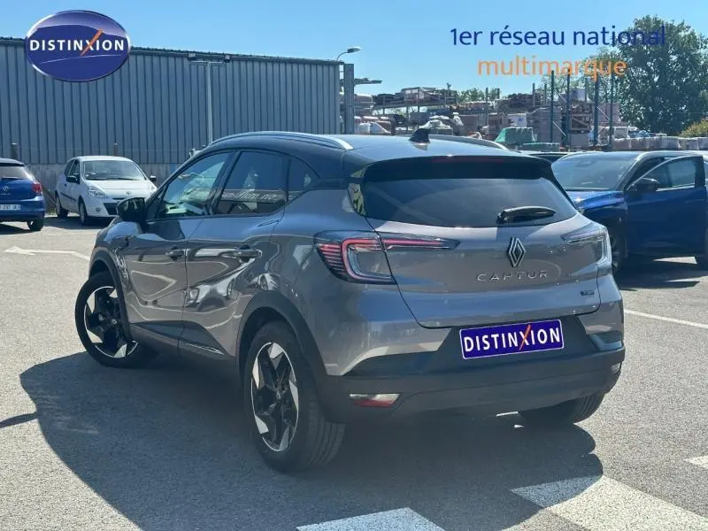 Vue 3/4 arrière droite du Renault Captur 2025 gris Cassiopée métallisé avec toit noir et jantes alu distinctives.