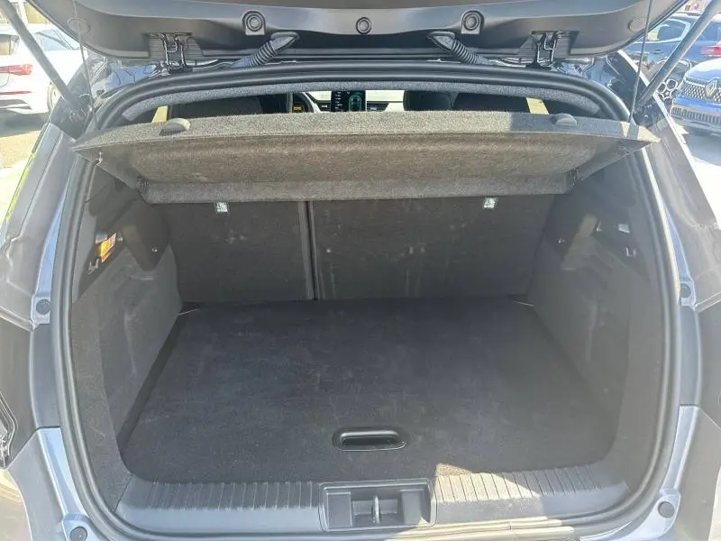 Coffre ouvert vu de l'arrière d'un Renault Captur 1.6 E-Tech gris Cassiopée métallisé/Noir Etoilé, espace de chargement vide.