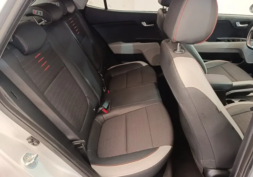 Vue intérieure côté droit montrant la banquette arrière noire avec surpiqûres rouges du KIA Stonic gris clair 2019.