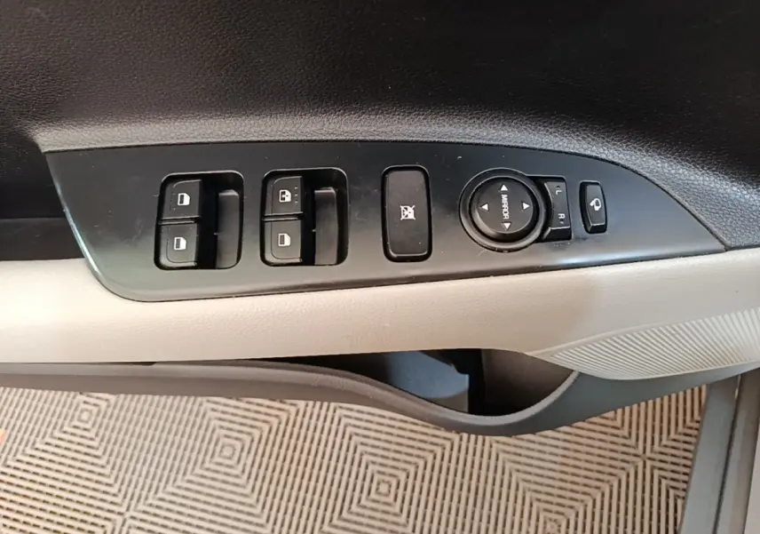 Panneau de commandes des vitres et rétroviseurs côté conducteur, intérieur gris clair du Kia Stonic 2019.