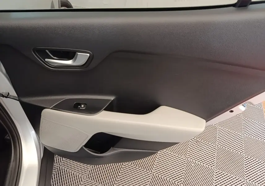 Vue intérieure côté gauche de la porte avant gris clair du KIA STONIC 2019 avec accoudoir beige et poignée argentée.