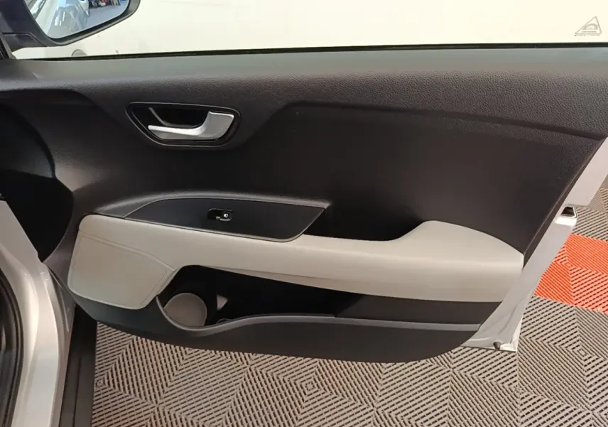 Vue intérieure du panneau de porte avant gauche gris clair et noir du Kia Stonic 2019 avec poignée argentée et rangement intégré.