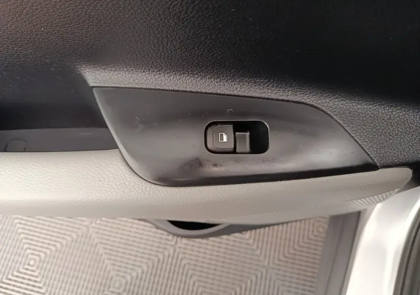 Bouton de verrouillage des portes sur la garniture intérieure côté conducteur d'une KIA Stonic gris clair.