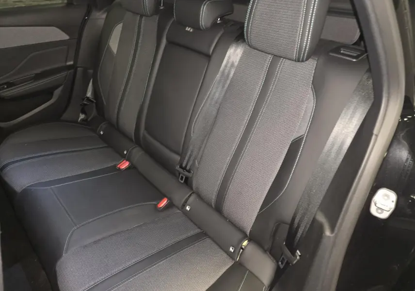 Vue latérale droite de la banquette arrière noire et tissu gris avec surpiqûres bleues du Peugeot 308 SW 2024.