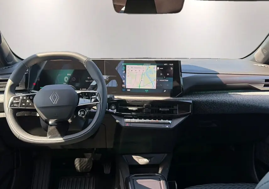 Vue intérieure avant du tableau de bord de la Renault Clio VI noire avec écran tactile central et volant multifonction.