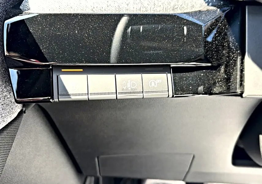 Gros plan sur les commandes sous le tableau de bord de la Renault Clio VI noire, avec finition brillante noire.