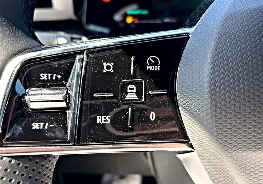 Gros plan sur les commandes de régulateur de vitesse sur le volant noir de la Renault Clio VI 1.2 TCe 115 Techno EDC.