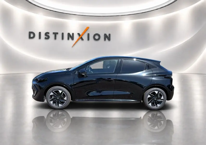 Profil côté gauche de la Renault Clio VI noire 2026 avec jantes alu et vitres arrière surteintées dans un showroom lumineux.