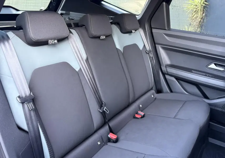 Vue latérale droite de la banquette arrière noire et grise du Dacia Bigster 2025 avec ceintures et appuie-têtes intégrés.