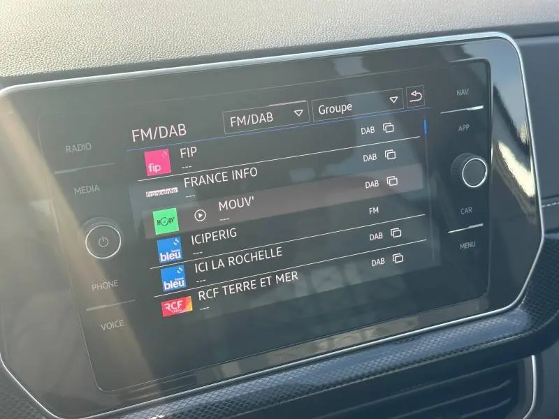 Écran tactile central du Volkswagen T-Cross 2025 affichant les options radio FM/DAB dans un intérieur moderne.