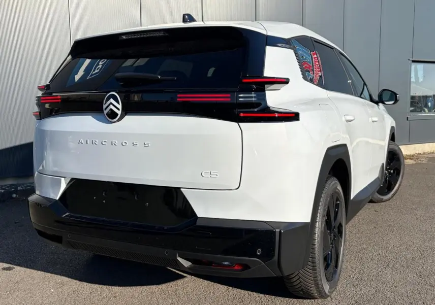 Vue 3/4 arrière droite du Citroën C5 Aircross blanc Okenite avec hayon électrique et jantes noires.