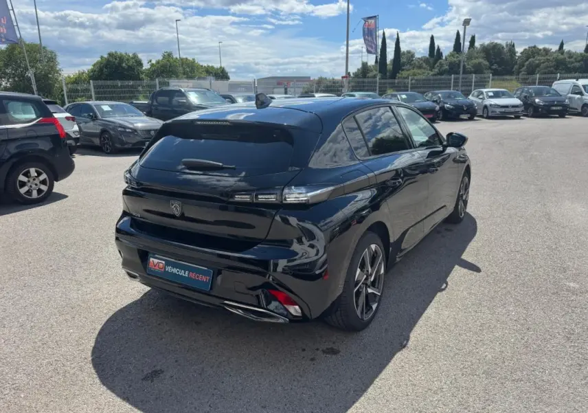 Peugeot 308 Hybrid noir vue en 3/4 arrière droit, avec jantes alliage 17 pouces et vitres teintées.