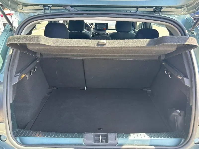 Coffre ouvert vu de l'arrière d'une Dacia Sandero 1.0 ECO-G 100ch Stepway Extreme vert cèdre métallisé, intérieur noir.