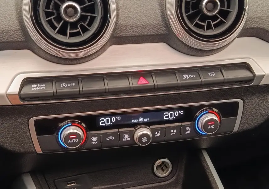 Détail de la console centrale de l’Audi Q2 noir 2021, montrant la climatisation digitale bi-zone à 20°C.