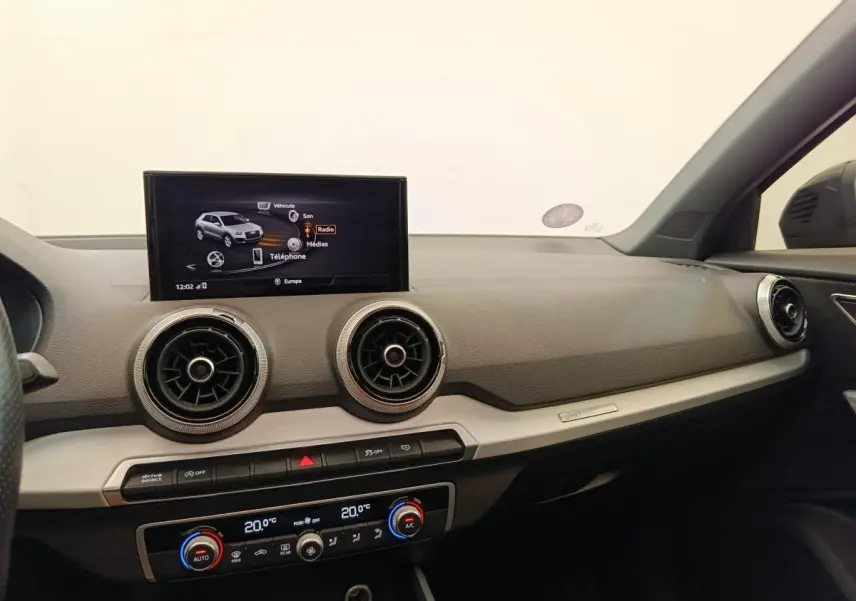 Intérieur de l'Audi Q2 35 TFSI 150 S Line 2021, vue du tableau de bord côté passager avec écran tactile et aérateurs ronds.