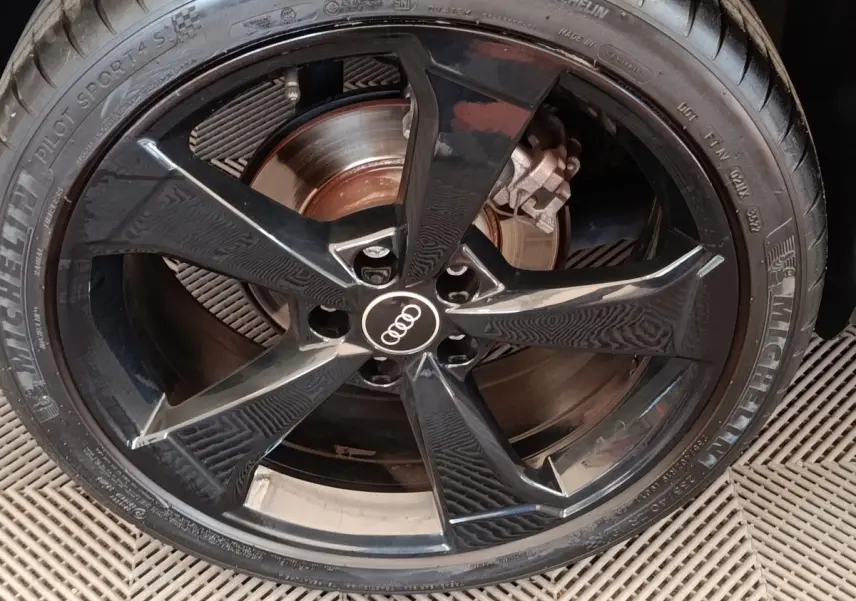 Gros plan sur la jante noire brillante Audi à cinq branches du Q2 35 TFSI 150 S Line avec pneu Michelin Pilot Sport 4 S.