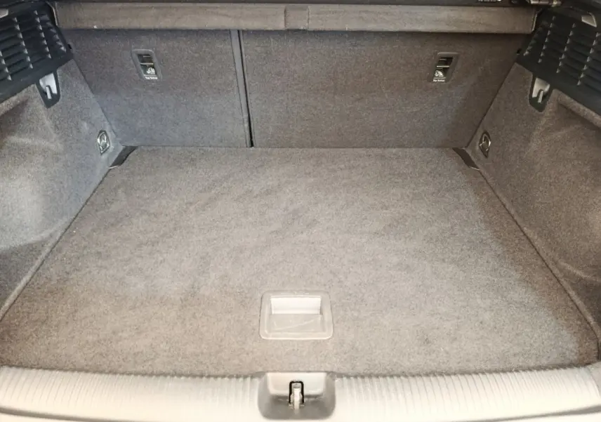 Vue intérieure du coffre spacieux et tapissé de gris de l'Audi Q2 35 TFSI S Line noir, avec banquette rabattable 2/3-1/3.