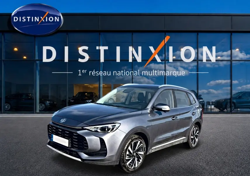 MG ZS 1.5 hybrid gris en 3/4 avant droit, avec calandre noire et jantes alliage 18 pouces visibles.