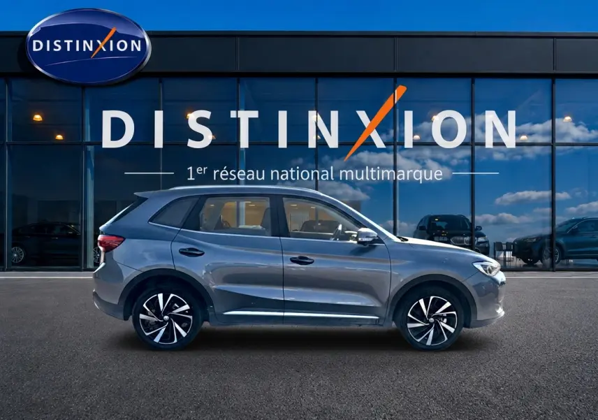 Vue profil côté gauche du MG Motor ZS 1.5 hybrid gris 2026, avec jantes alliage noires et détails chromés.
