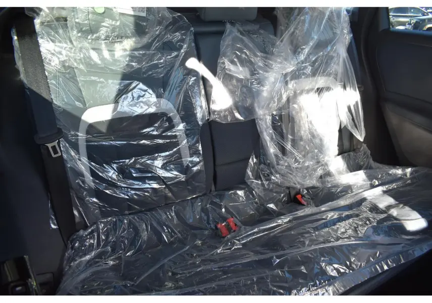Vue intérieure arrière du Citroën C5 Aircross blanc 2026, sièges protégés par housses plastiques transparentes.