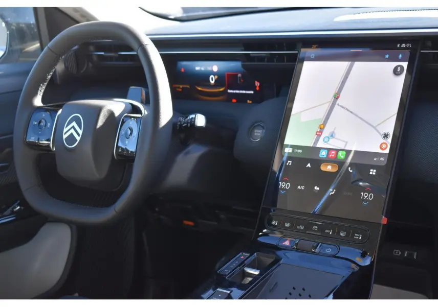 Vue intérieure du tableau de bord du Citroën C5 Aircross hybride blanc, avec écran tactile vertical et volant multifonctions.