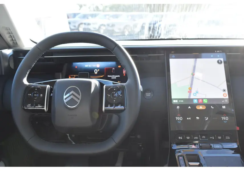 Vue intérieure centrée sur le volant multifonctions et l'écran tactile vertical du Citroën C5 Aircross blanc.
