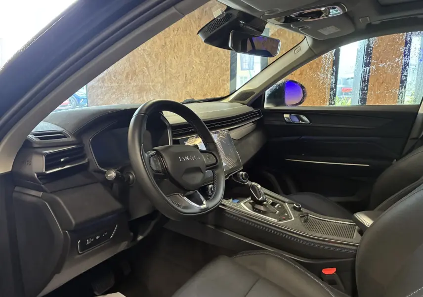 Intérieur noir du Lynk & Co 01 vu côté conducteur, avec tableau de bord moderne et écran tactile central.